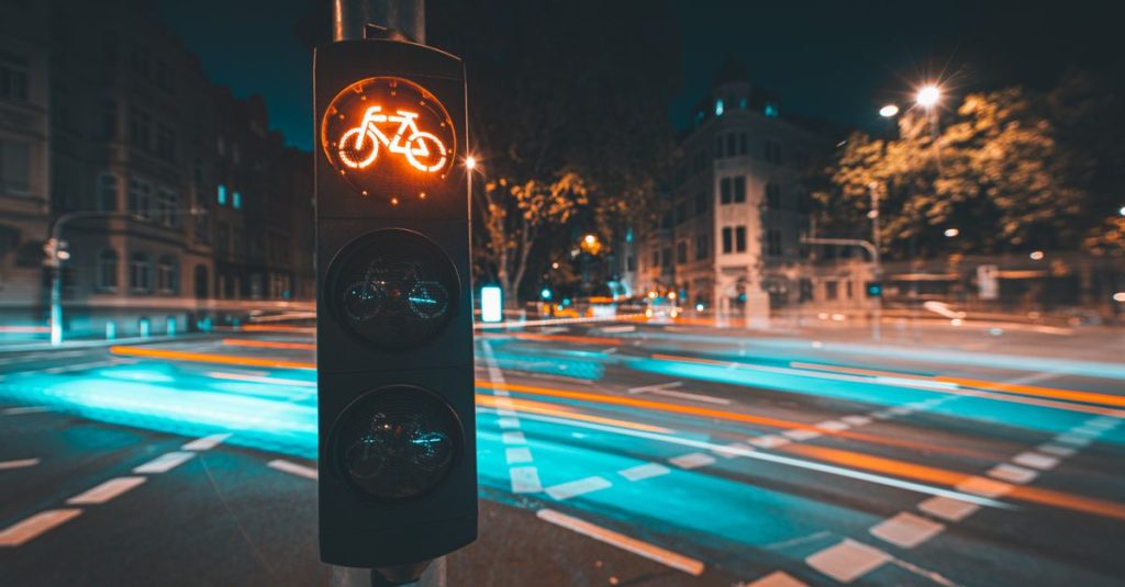 Bicycle traffic light with light trails in Wiesbaden at night, showcasing urban life and motion.
