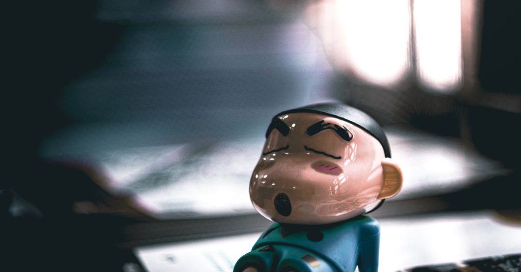 Close-up of a cartoon figurine sleeping on a table with soft lighting.