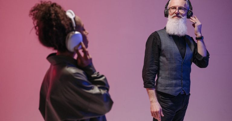 Elderly man and woman with headphones enjoying music in modern studio.