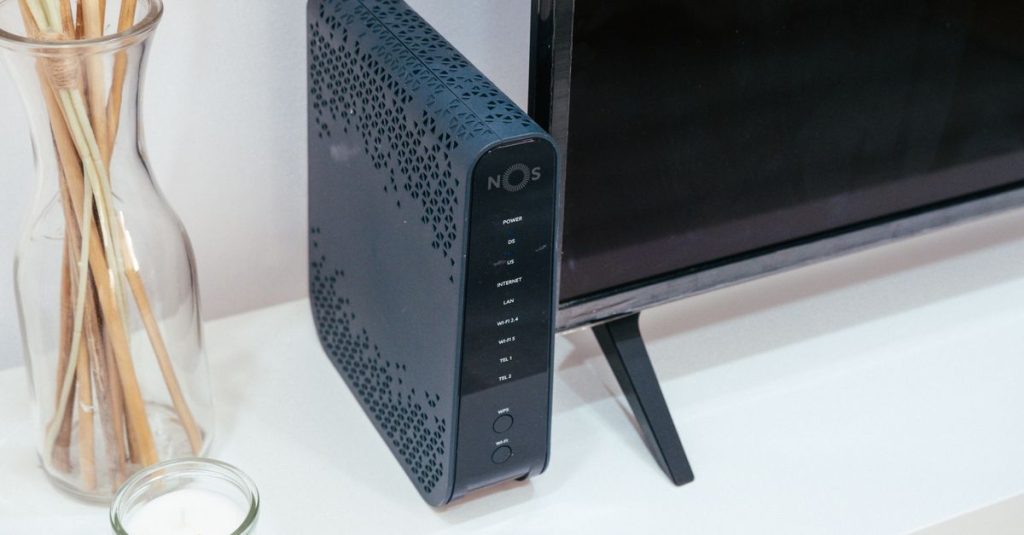 A sleek home technology setup featuring a router, glass decoration, and television.
