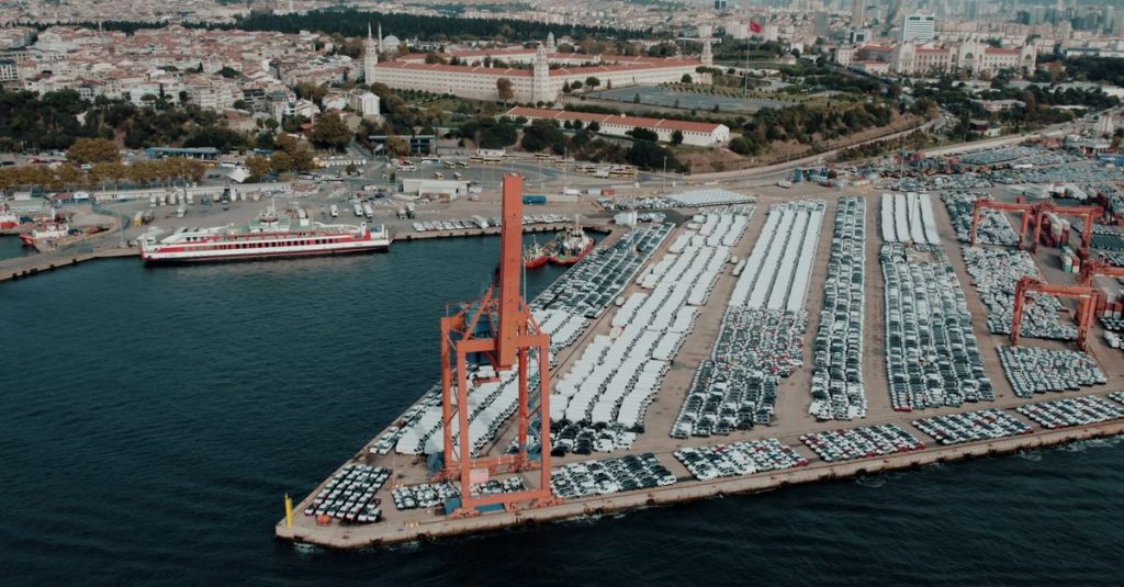 Aerial view of a bustling car shipping terminal in Istanbul, Türkiye, showcasing a busy port with vehicles ready for export.