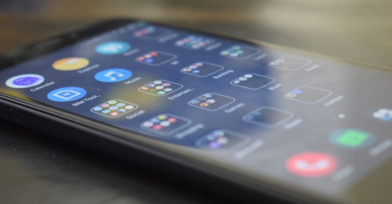 Close-up shot of a smartphone screen showing various app icons, indicating digital technology use.