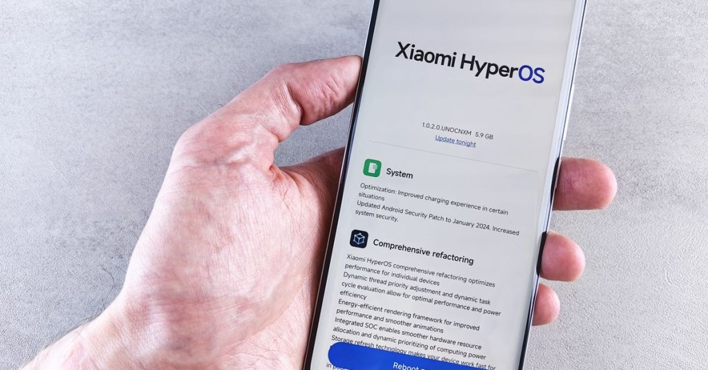 Close-up of a hand holding a Xiaomi smartphone with HyperOS interface, showcasing comprehensive refactoring and system update details.