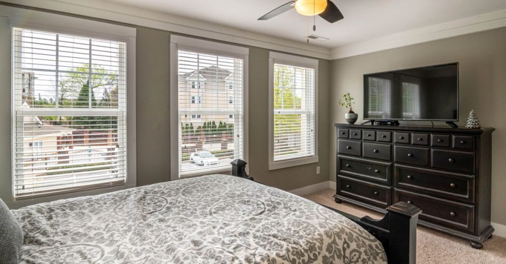 Spacious bedroom featuring elegant decor, modern furniture, and abundant natural light.