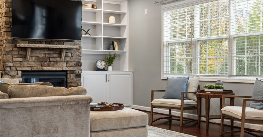 Cozy modern living room featuring stone fireplace and elegant furnishings.