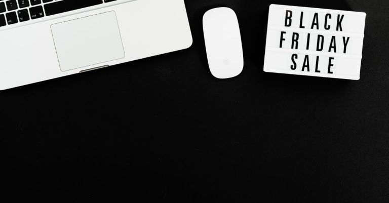 Black Friday sale sign with a laptop and mouse on a black background. Perfect for online shopping promotions.