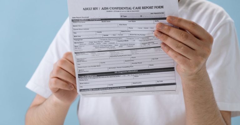 Person holding confidential HIV/AIDS case report form, symbolizing health awareness and privacy.
