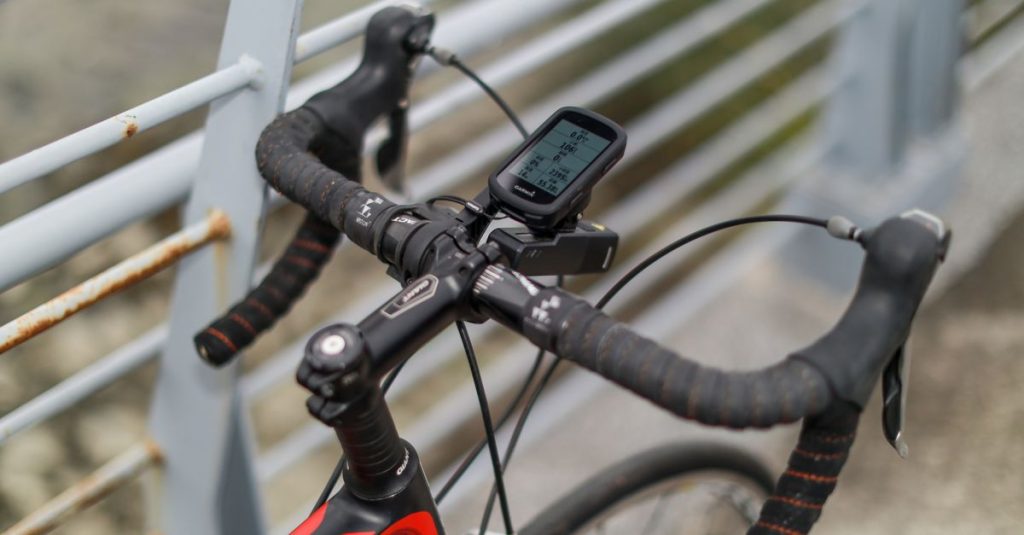 Close-up of a bicycle handlebar with a bike computer in Taipei's urban setting.