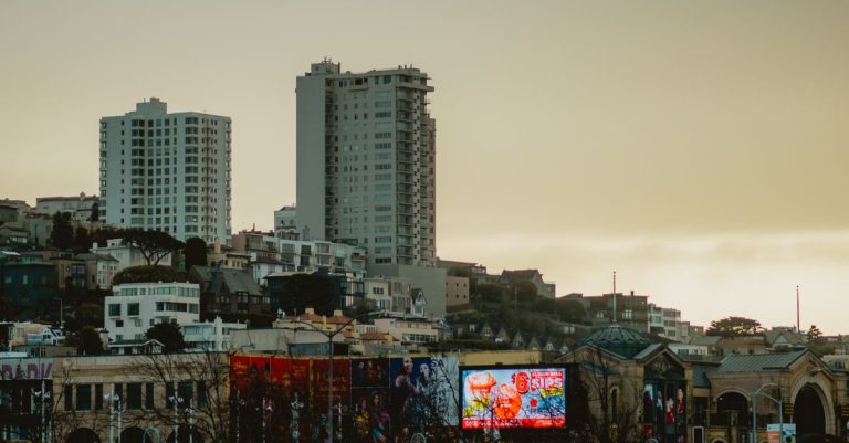 San Francisco skyline with prominent billboards during a calm dusk sky, showcasing urban architecture.