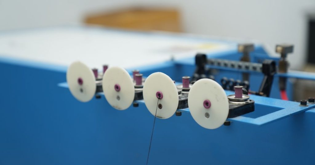 Detailed view of a blue industrial machine with white wheels, highlighting its mechanical parts.