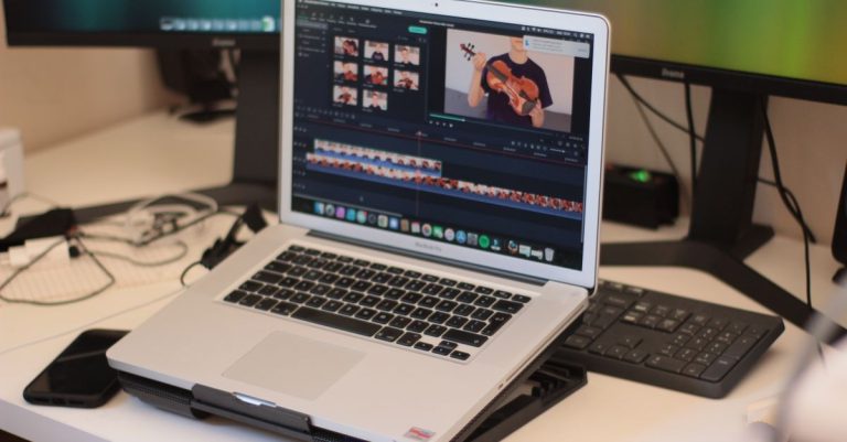 A workspace featuring a laptop editing a video, showcasing modern technology and video editing software.