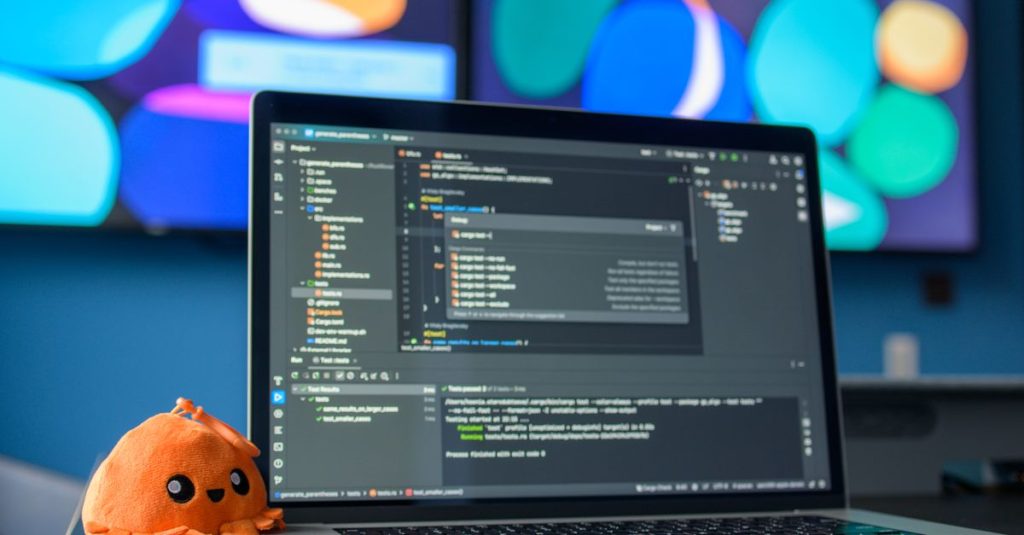 Colorful workspace featuring a laptop with code editor and vibrant screens.