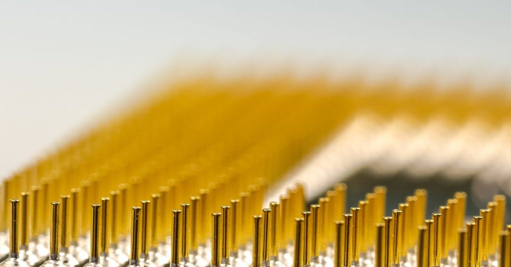 Detailed macro shot of a CPU microchip with focus on golden pins, highlighting technology details.