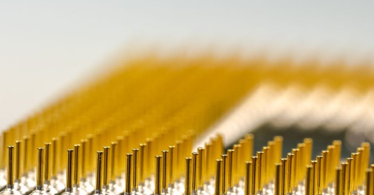 Detailed macro shot of a CPU microchip with focus on golden pins, highlighting technology details.