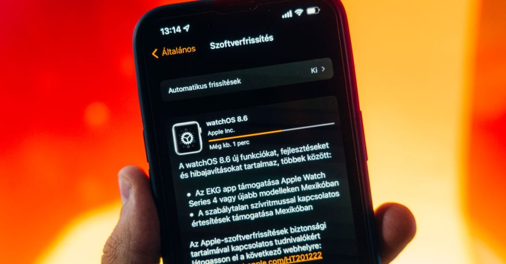 Hand holding a smartphone displaying WatchOS 8.6 update notification against warm gradient background.