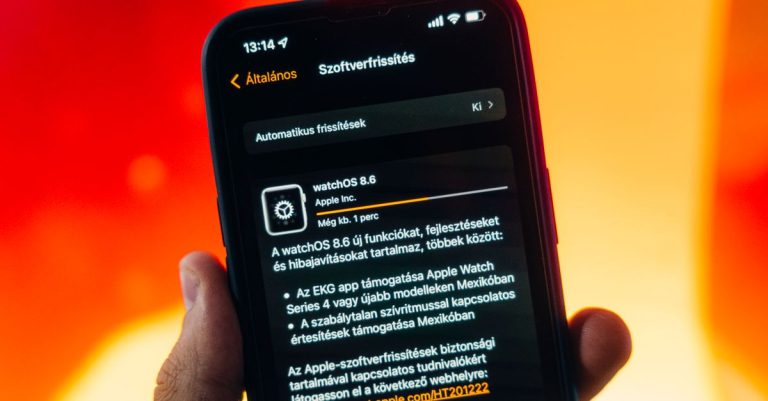 Hand holding a smartphone displaying WatchOS 8.6 update notification against warm gradient background.