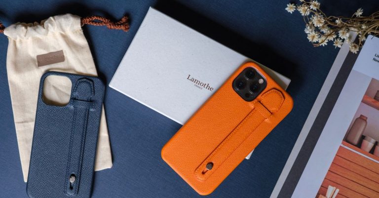 Elegant leather phone cases displayed with accessories on a dark table.