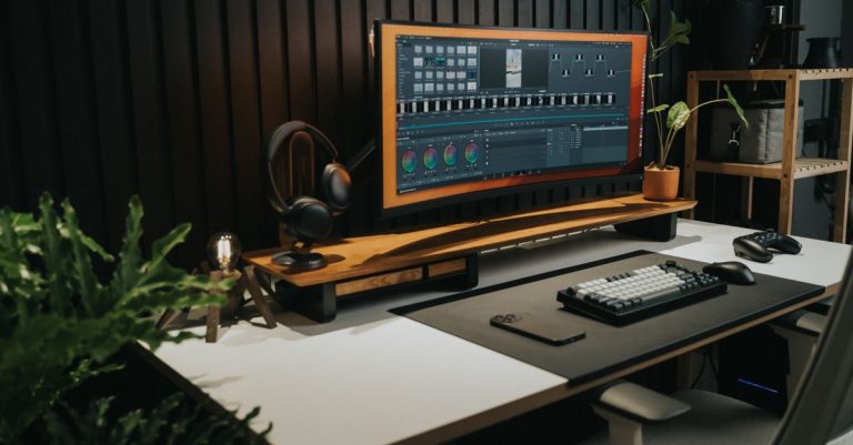Sophisticated office workspace with a sleek ultra-wide monitor, keyboard, and plants, perfect for tech enthusiasts.