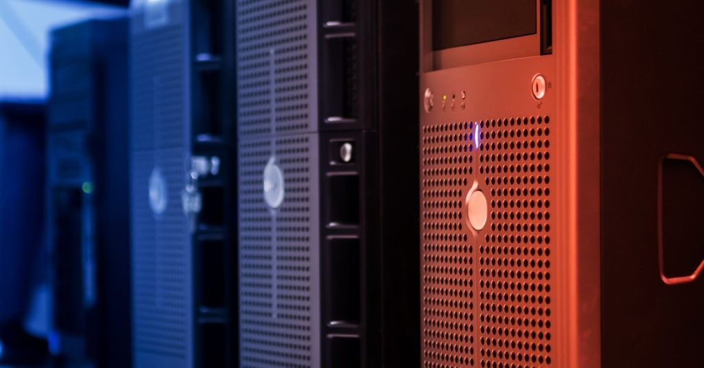 Close-up of tower servers in a data center with blue and red lighting.
