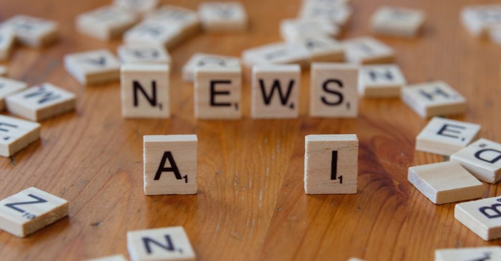 Wooden Scrabble tiles spelling 'AI' and 'NEWS' for a tech concept image.