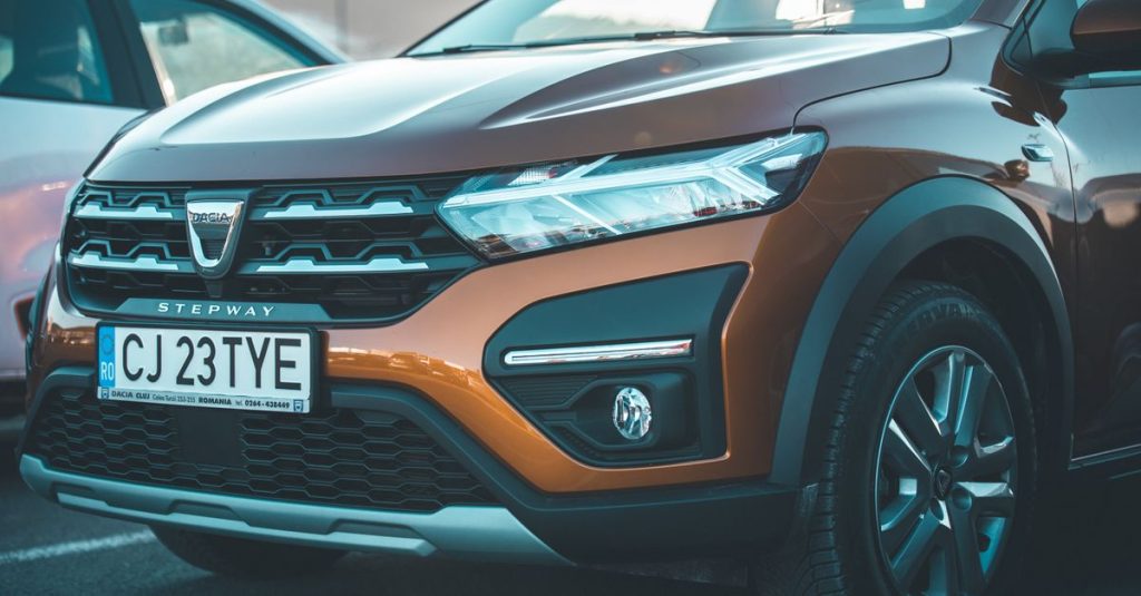Close-up of a brown Dacia Stepway car showcasing its front grille and headlights.