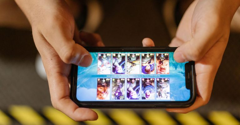 Close-up of hands playing a mobile game on a smartphone, showcasing the game's interface.