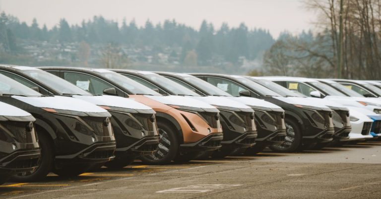 Rows of sleek electric cars parked outdoors, showcasing automotive design and innovation.