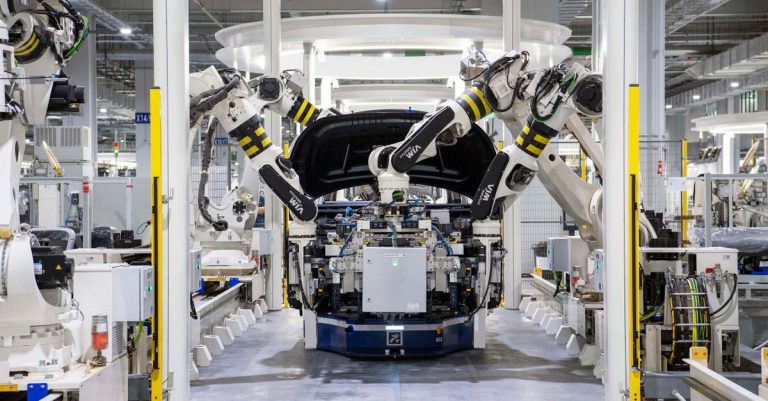 High-tech robots assembling a car in a modern factory setting, showcasing automation.