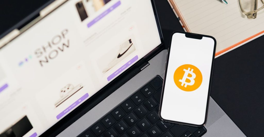 Laptop and smartphone with Bitcoin symbol, depicting digital shopping