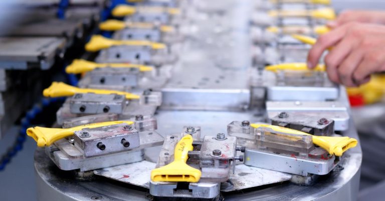 Close-up of a factory production line with yellow components being assembled.