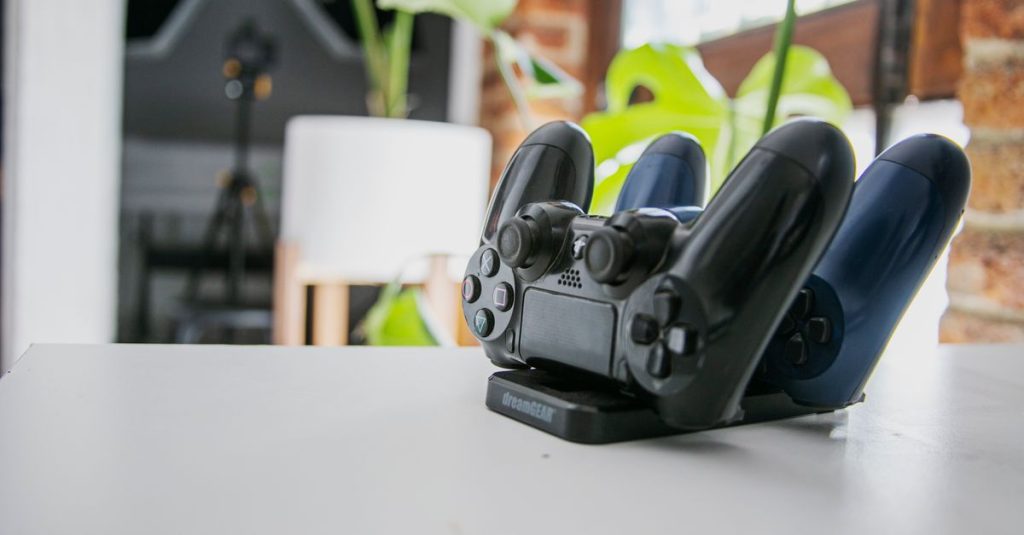 A wireless game controller resting on a charging dock in a modern indoor setting, showcasing gaming technology.