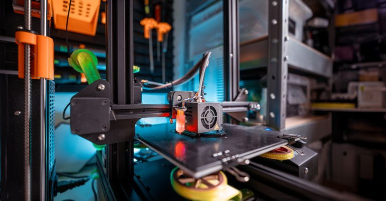 Detailed view of a 3D printer actively working in a workshop environment, showcasing modern technology.