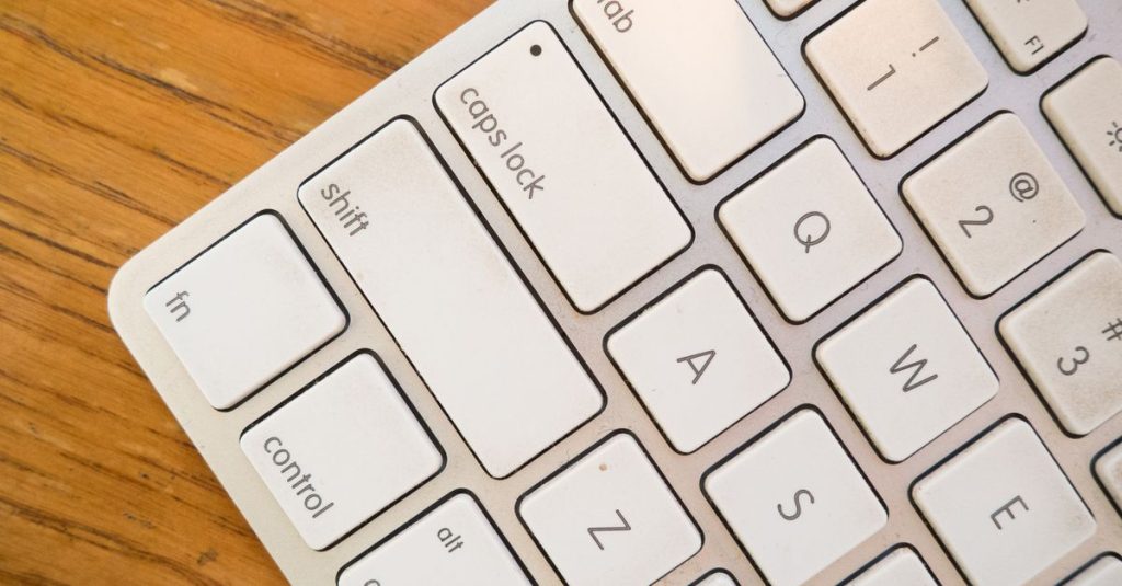 A detailed close-up of a modern computer keyboard on a wooden desk.