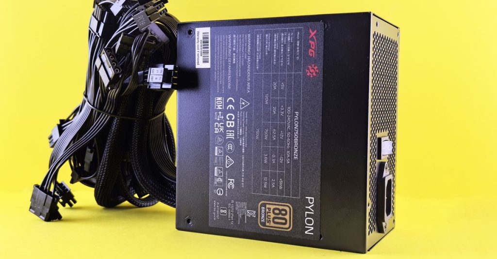 Black PC power supply unit with cables on a vibrant yellow backdrop. Ideal tech image.